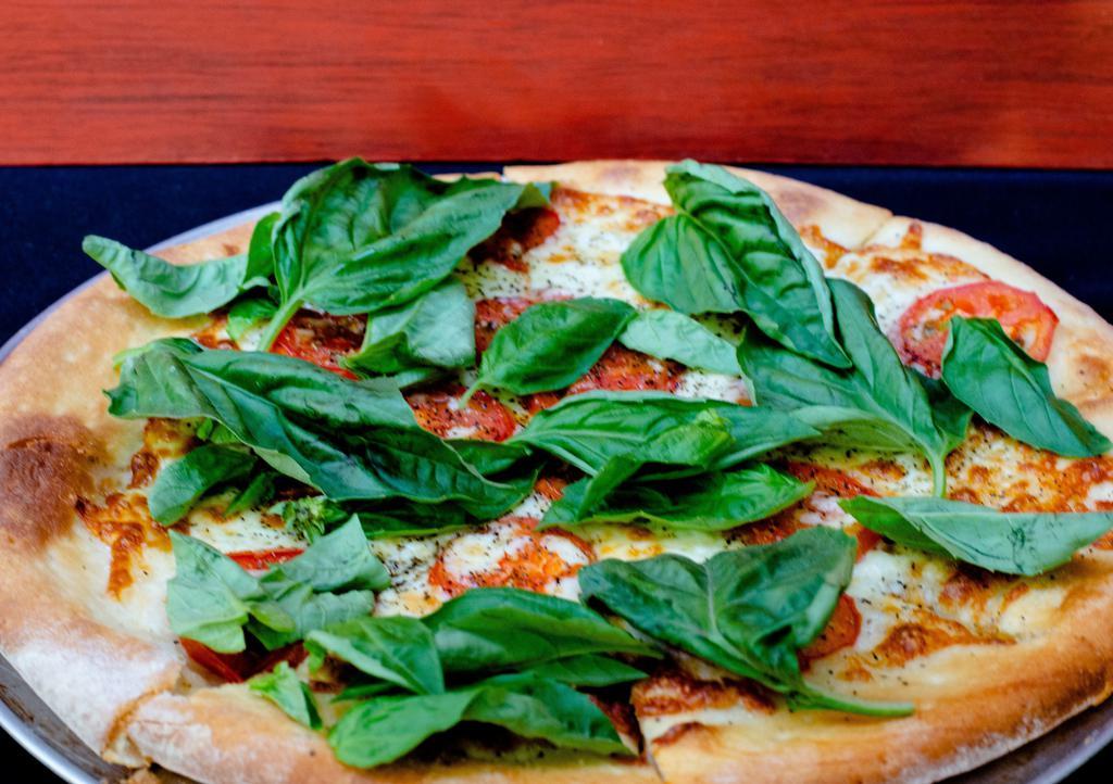 Margherita · Fresh shredded mozzarella, choice tomatoes, topped with fresh basil and olive oil.