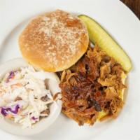 Pulled Pork · Slow smoked pulled pork piled on toasted bun with side dish.