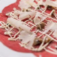 Carpaccio Di Manzo · Beef carpaccio with marinated mushrooms, capers, grana padano cheese and mustard sauce.