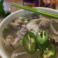 Beef Pho · Vietnamese rice noodle soup with well done thin sliced beef steak and onions, served with si...