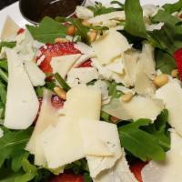 Arugula Salad · Fresh arugula greens tossed with roasted pine nuts, fresh strawberries, and shaved parmigian...