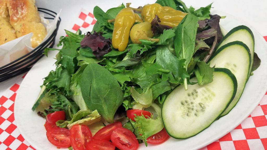 Garden Salad · Romaine lettuce and mixed greens topped with fresh tomato, cucumber, and peperoncini.
