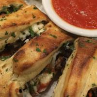 Stramboli Roll · Rolled pizza with mozzarella cheese, topping, and brushed with our garlic butter. Served wit...
