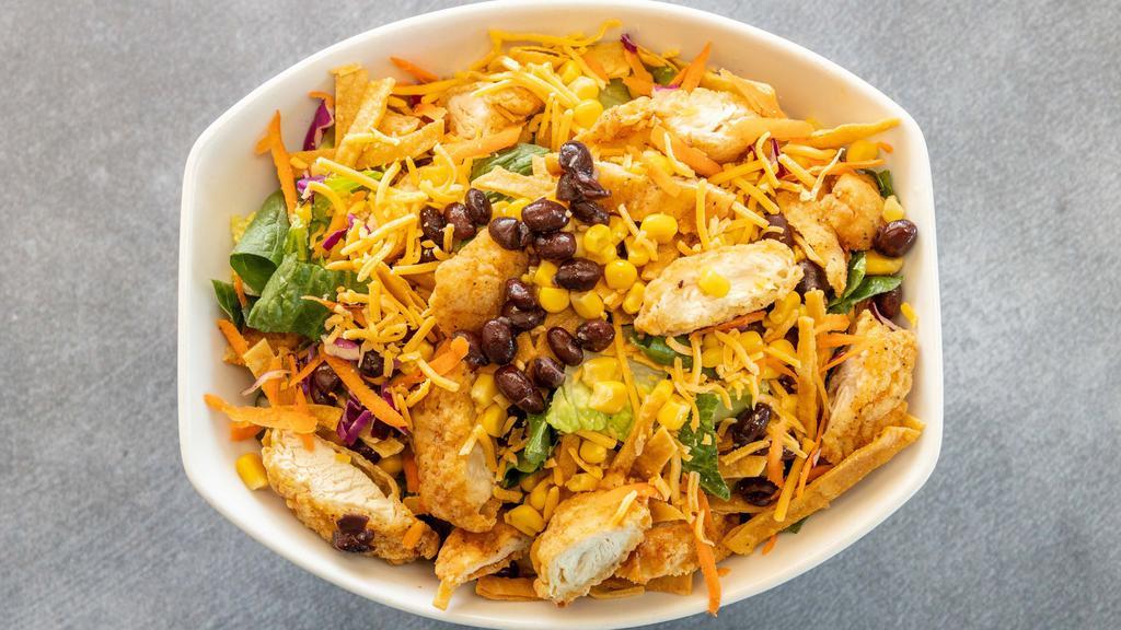 Southwest Crispy Chicken Salad · Crisp romaine lettuce with crispy chopped chicken tenders, black beans, corn, cheddar cheese, and crispy fried tortillas. Served with chipotle ranch unless specified.