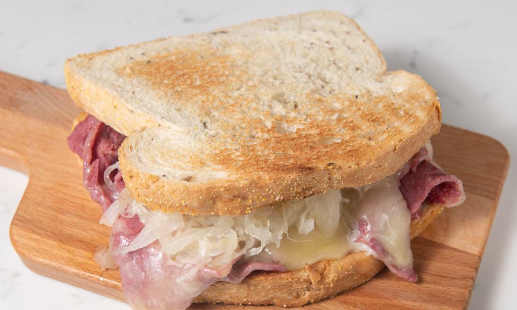 Reuben Sandwich · First cut corned beef with swiss cheese melted on top, sauerkraut, and  thousand island dressing served with toasted rye bread.