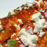 Enchiladas · Two red-sauce enchiladas topped with lettuce, sour cream, cotija cheese, avocado, mild salsa...