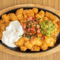 Rockin Tots · Skillet of tots toast with nacho cheese, cheddar cheese, sour cream, guacamole, and pico de ...