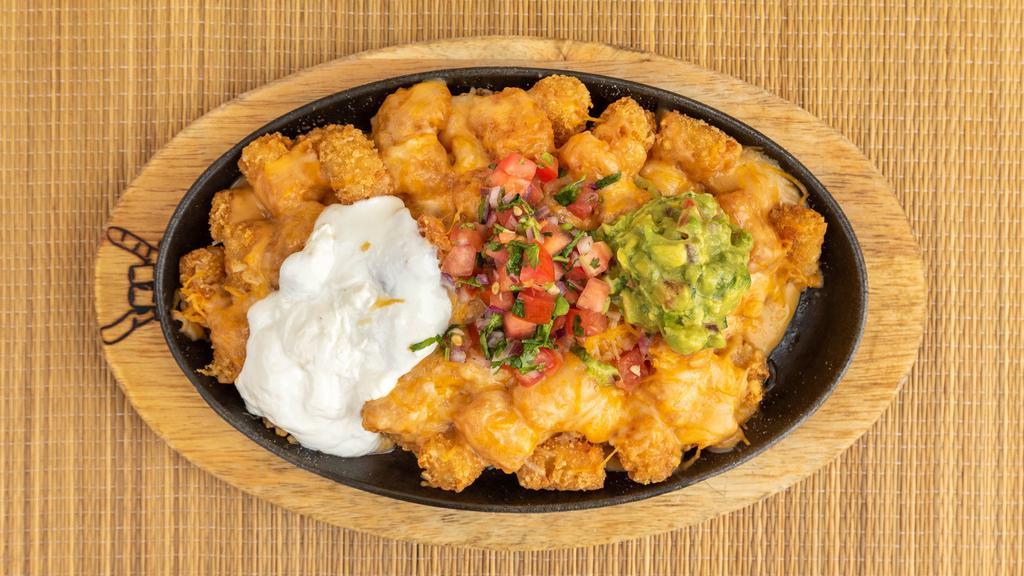 Rockin Tots · Skillet of tots toast with nacho cheese, cheddar cheese, sour cream, guacamole, and pico de gallo.