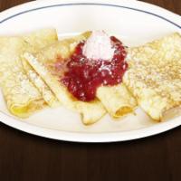 Strawberry Crepes · Four crepes topped with strawberries and vanilla cream sauce.
