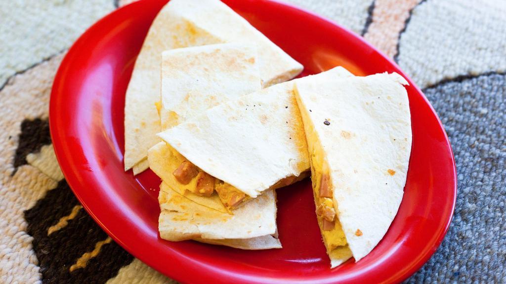 Breakfast Quesadilla · A large flour tortilla lightly grilled and folded with melted cheese, two scrambled eggs and your choice of breakfast meat inside.