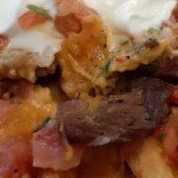 Asada Fries · Crispy french fries topped with carne asada, Cheddar and Jack Cheese, salsa cruda and our mi...