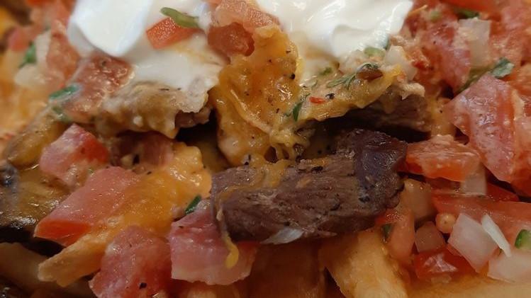 Asada Fries · Crispy french fries topped with carne asada, Cheddar and Jack Cheese, salsa cruda and our mildly spicy chipotle cream sauce.