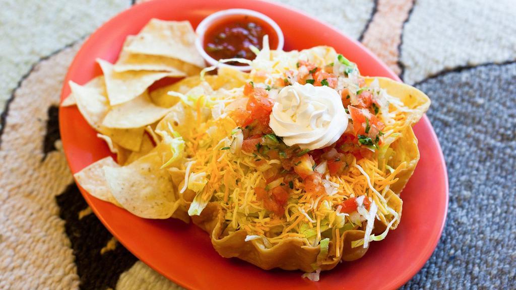 Taco Salad · A large flour tortilla shell filled with lettuce and your choice of meat then topped with two cheeses, salsa cruda, and sour cream.