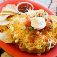 Tostada · Crispy flour tortilla shell filled with your choice of meat, pinto beans, and lettuce then t...