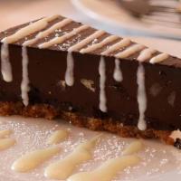Chocolate Pecan Tart · Decadent flourless chocolate tart with chopped pecans on a thick graham cracker crust warmed...