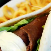Gyros Wrap · Caramelized, juicy and tender carved directly from the spit, served with tzatziki sauce.