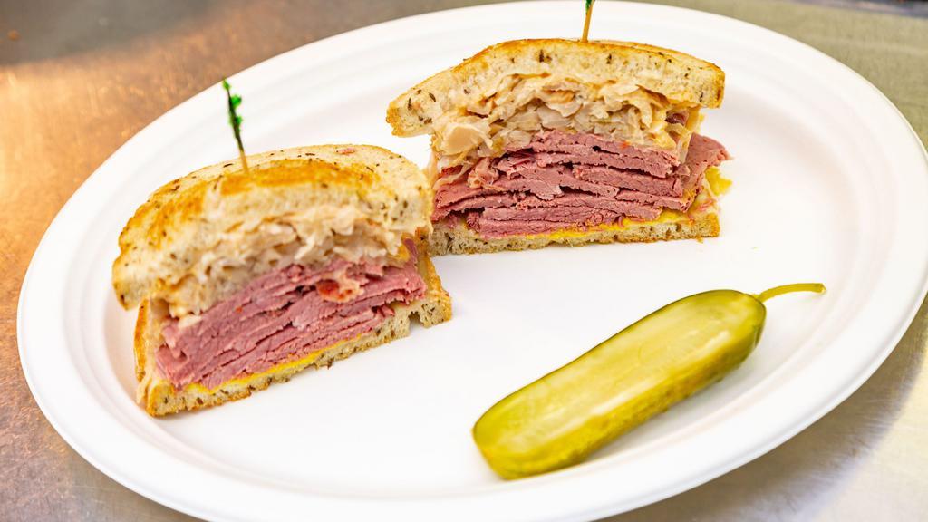 Reuben · Corned beef on grilled rye with melted swiss cheese, sauerkraut, 1000 island, and spicy Mustard.