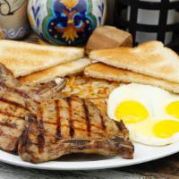 Pork Chop & Eggs Breakfast · Two pork chops two eggs hash brown two slices of toast and jelly.