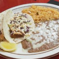 2 Baja Tacos · Crispy fried fish taco, with mixed slaw topped off with chipotle cream.  Served with rice & ...