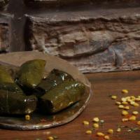 Dolmeh / دولمة · Cooked grape leaves filled with rice, split peas and fresh herbs.