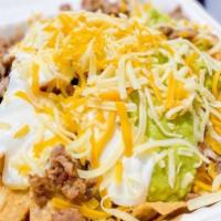 Nachos Supreme · served with meat, cheese, beans, guacamole, and sour cream.