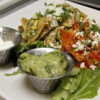 Chilaquiles Bandera · Sautéed eggs with corn tortilla chips, chipotle, red and green sauce with onions, cilantro a...