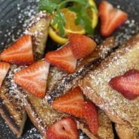 French Toast Breakfast · Four slices of french toast topped with fresh fruit, maple syrup, and whipped cream.