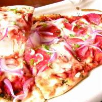Garlic Naan Bread Pizza · Topped w/ pepperoni, tomato, onion & mozzarella cheese.