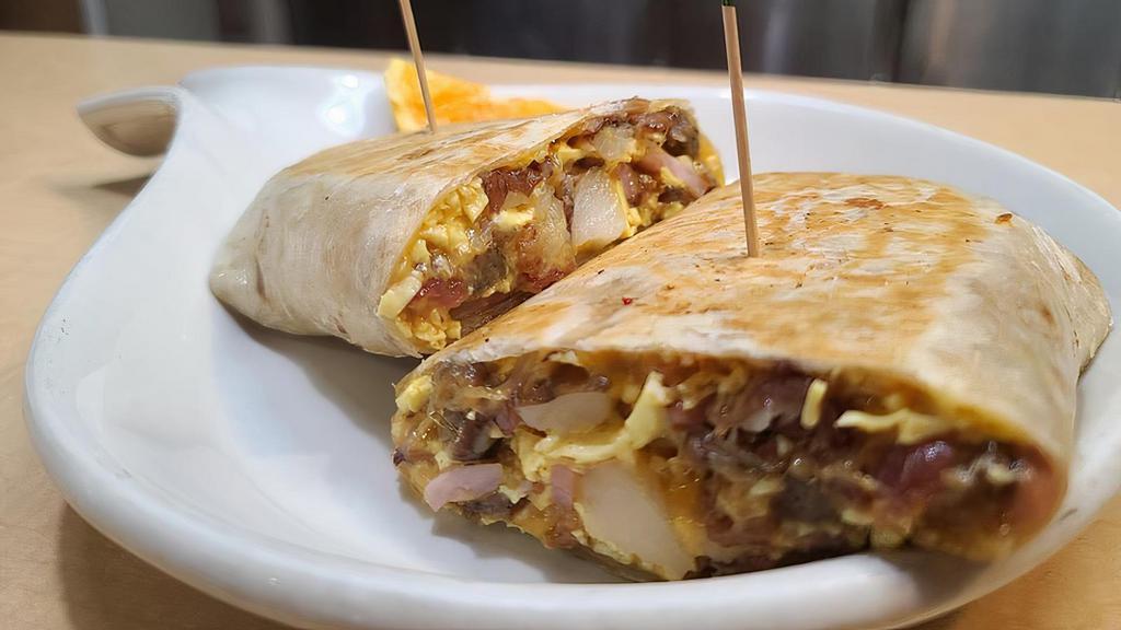 Meat Lovers Breakfast Burrito · Our  Meat lovers burrito is fully loaded with bacon, sausage, ham, 3 eggs, a hash brown, cheddar cheese, onions, and tomatoes. Tortilla is grilled golden
