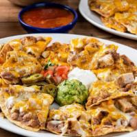 Grande Fajita Nachos · Tostada chips topped with refried beans, fajita chicken or steak and melted mixed cheese. Se...