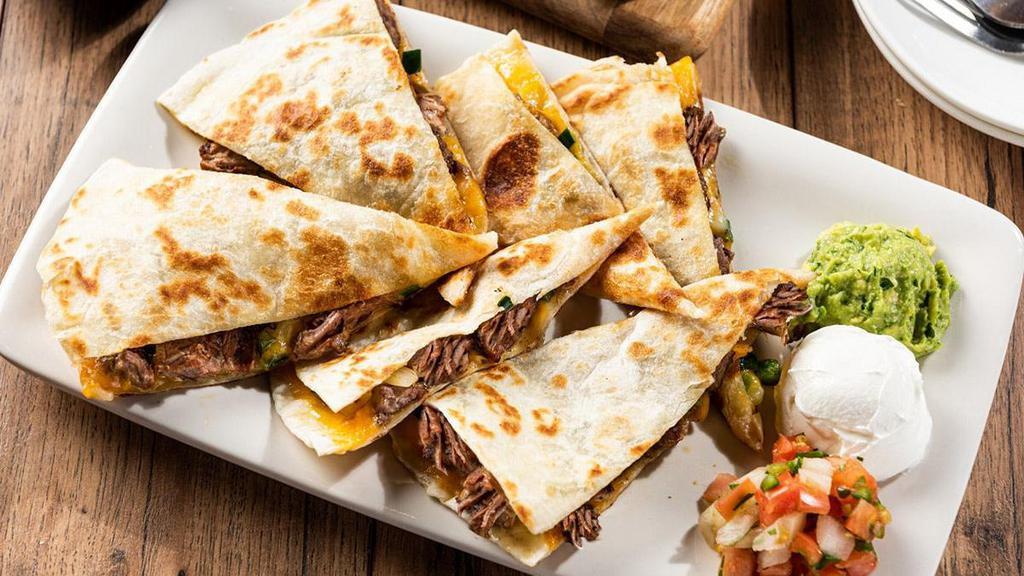 Brisket Quesadillas · 1310 cal. Brisket with sautéed onion and pickled jalapeños. Served with jalapeño-bbq sauce, roasted red chili salsa inside, guacamole, sour cream, and pico de gallo.