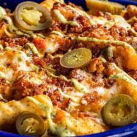 Texas Queso Fries · Queso smothered fries, topped with melted white Mexican cheese, crispy bacon crumbles, spicy...