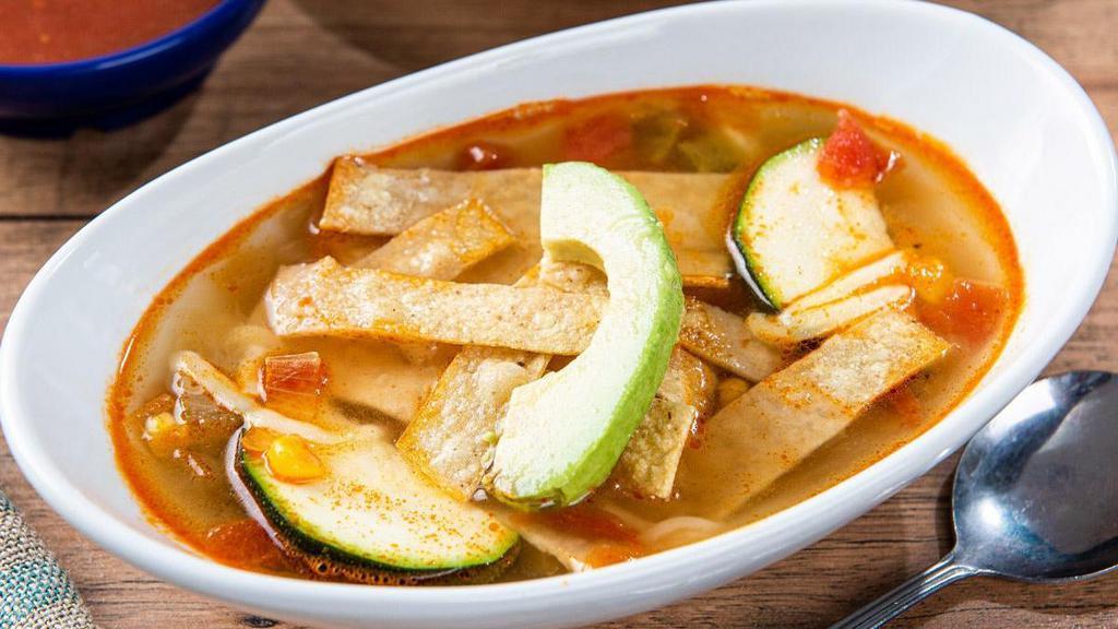 Chicken Tortilla Soup · Homemade chicken broth loaded with chicken tinga, rice, zucchini, and Jack cheese, topped with fresh avocado and tortilla strips.