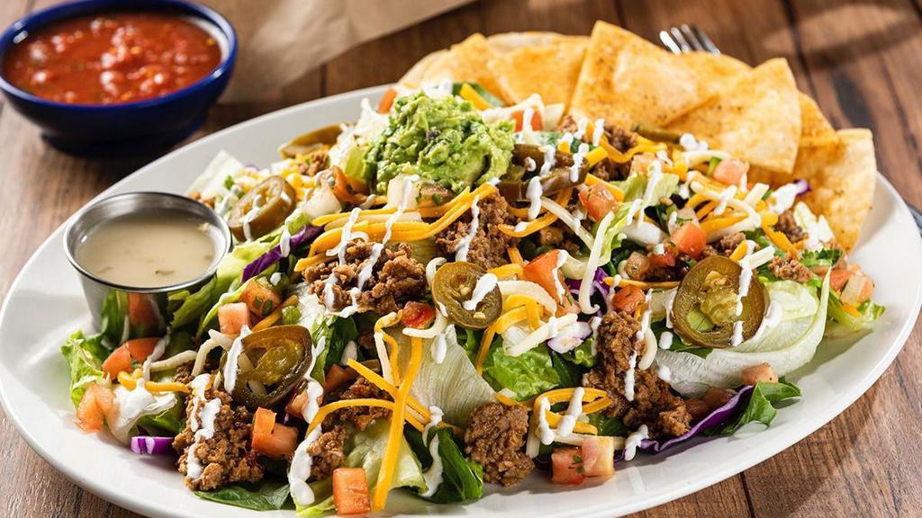 Grande Taco Salad · Seasoned ground beef or chicken tinga on a crisp blend of lettuce & shredded cabbage, mixed cheese, fresh guacamole, lime crema, pico de gallo and pickled jalapeños. Served with seasoned flour tortilla crisps.