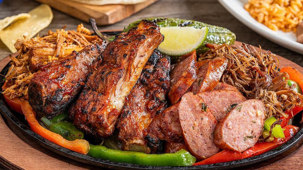Smokehouse Fajitas · Texas-sized fajita platter with chipotle ribs, jalapeño sausage, braised carnitas, shredded beef brisket and a grilled jalapeño. Served with honey chipotle and jalapeño-BBQ sauces, hand-pressed flour tortillas, pico de gallo, cheese, Mexican rice and choice of beans.