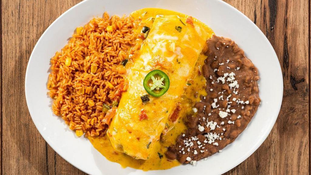 Classic Chimichanga · Our Classic Burrito fried crispy and smothered with chile con carne, sour cream sauce, salsa verde, roasted red chile tomatillo salsa or our signature queso. Served with Mexican rice and choice of beans.