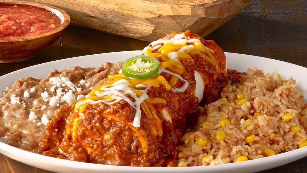 Classic Burrito · Seasoned ground beef or chicken tinga, pico de gallo and cheese rolled in a flour tortilla smothered with chile con carne, sour cream sauce, salsa verde, roasted red chile tomatillo salsa or our signature queso. Served with Mexican rice and choice of beans.
