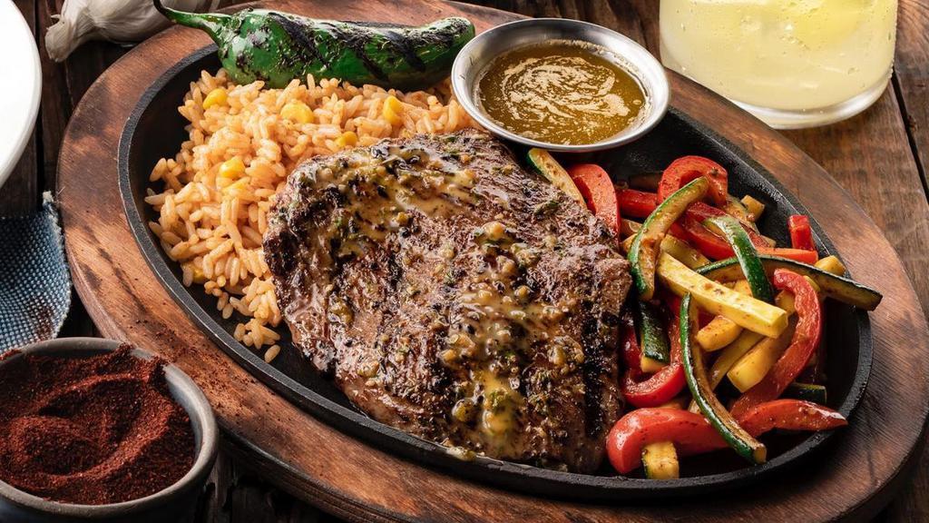 Carne Asada · A 9oz. marinated and seasoned mesquite-grilled steak served on a skillet with seasoned butter, sautéed vegetables and Mexican rice.