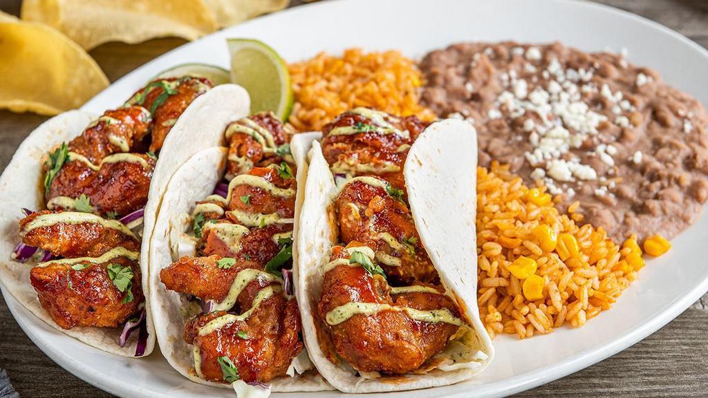 Honey Chipotle Shrimp Tacos · Crispy-fried shrimp tossed in honey chipotle sauce with cilantro, spicy avocado ranch and shredded cabbage in hand-pressed flour tortillas. Served with Mexican rice and choice of beans.