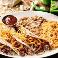 Brisket Tacos · Shredded beef brisket, Jack cheese, fried onion strings and jalapeño-BBQ sauce in hand-press...