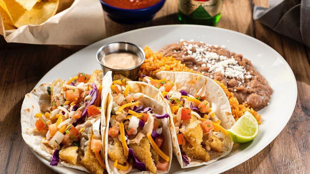 Dos Xx® Fish Tacos · Dos XX beer-battered fish, creamy red chile sauce, shredded cabbage, mixed cheese and pico de gallo in hand-pressed flour tortillas. Served with Mexican rice and choice of beans.