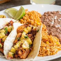 Tacos Al Pastor · Seasoned, braised carnitas and pineapple salsa in hand-pressed flour tortillas. Served with ...