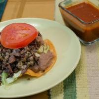 Tostada With Meat · Flat crunchy tostada with choice of meat, beans, lettuce, guacamole, pico de gallo, cheese a...
