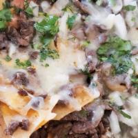 Nachos · Queso Monterey Jack, frijoles, queso de nacho, carne, salsa, crema, cebolla y cilantro. / Mo...