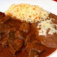 Carne Con Chile Colorado · Cubed beef in a red wine herb sauce. Served with rice and refried beans