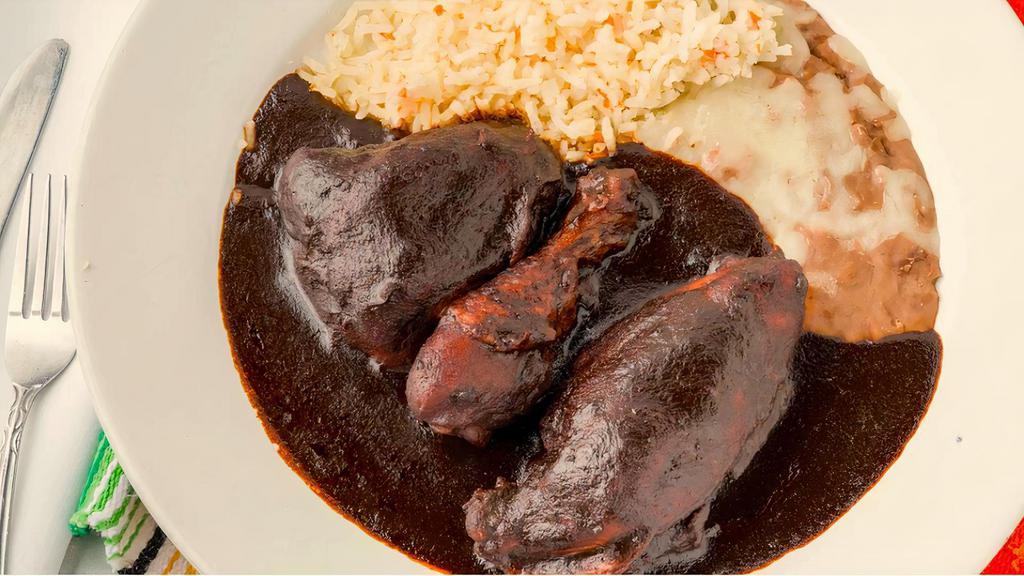 Chicken En Mole · Chicken smothered in a rich chocolate sauce with ingredients from all over Mexico. Served with rice and beans.