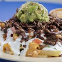 Super Fries · French fries topped with choice of meat, refired beans, nacho cheese, fresh guacamole, sour ...