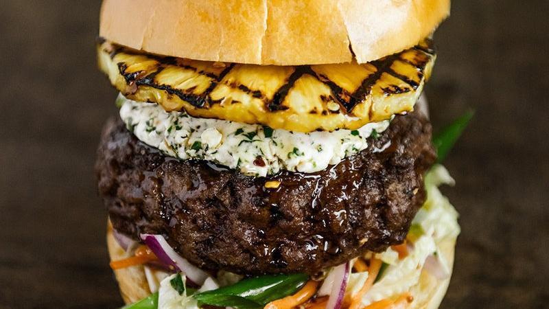 Hawaiian Burger · Beef burger, grilled pineapple, teriyaki glaze, Napa slaw, scallions, red onion, herb goat cheese, brioche bun