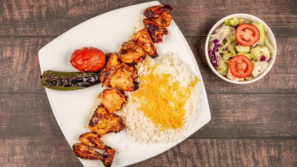 Cornish Chicken · Marinated Cornish hen grilled and seasoned. Served with grilled tomato, basmati rice, saffron, and salad.
