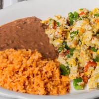 Huevos A La Mexicana · scrambled eggs cooked with chili peppers, onion, and tomato. served with rice and beans